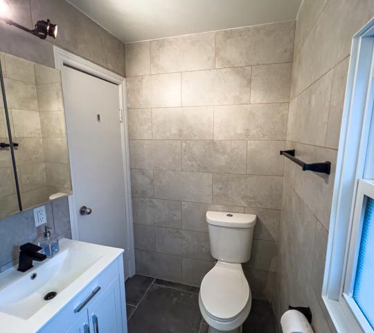 tiled walls with 24-inch vanity and toilet